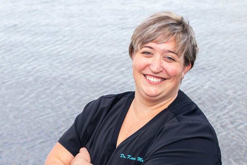 kari mann outside confidently arms crossed near water